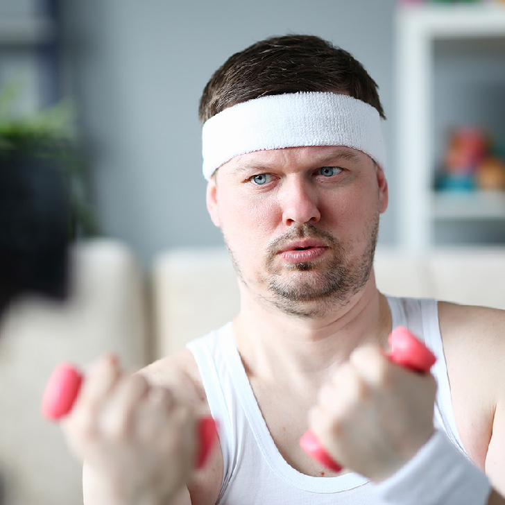 Harry Smith wearing a headband and liftin comically small pink weights